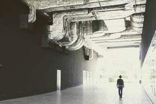 man looking a duct work in a commercial building