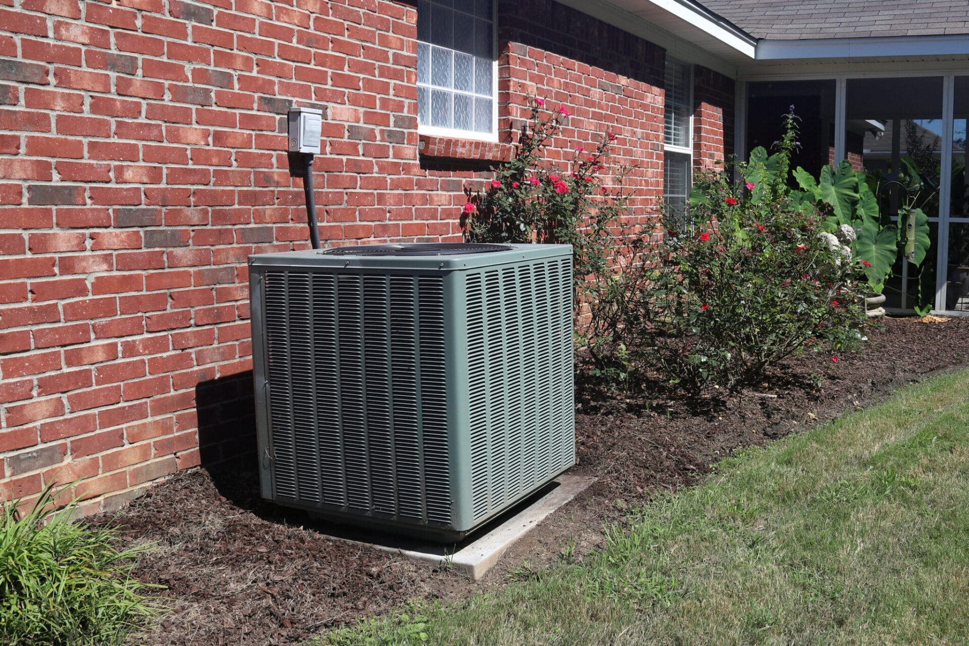 Home HVAC Unit next to modern brick home.